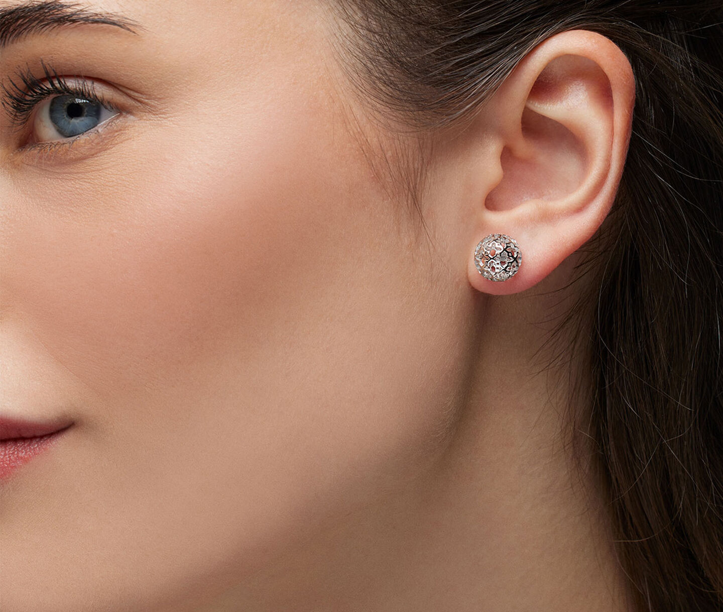 A woman wearing Birks Muse silver stud earrings.
